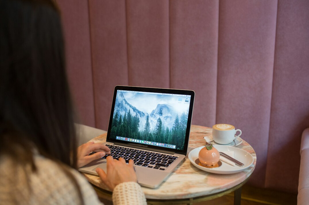 woman coding on laptop in cafe
